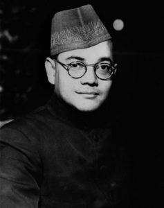 Photo of Subhas Chandra Bose as a young man wearing a traditional boys cap and glasses. 