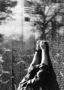 a man is slumped over the wall of names