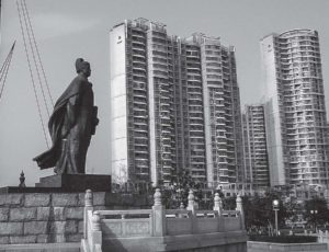 photo of a statue in front of several tall buildings