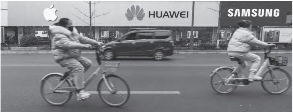 photo of two people biking past apple, huawei, and samsung store