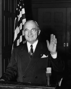 a man in a suit holds his hand up in greeting