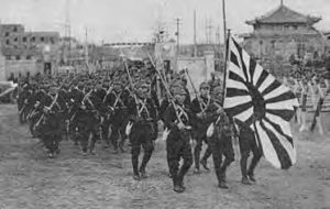 photo of a large group of japanese soldiers carrying their imperial flag.